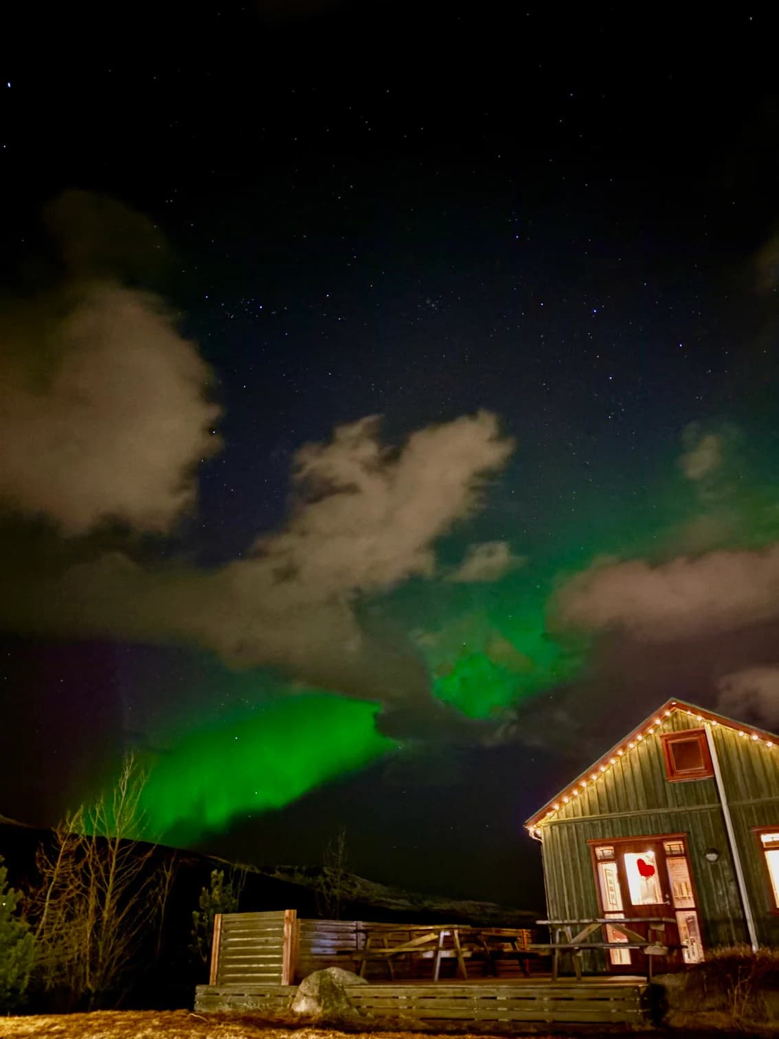 Aurora glowing above a remote Icelandic cabin
