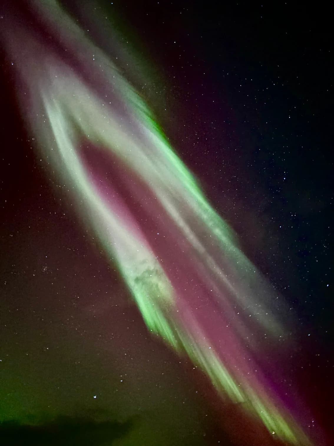 Green and magenta northern lights dancing across the sky