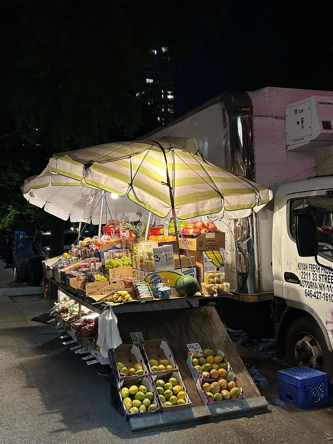 A neighborhood produce stand after dark