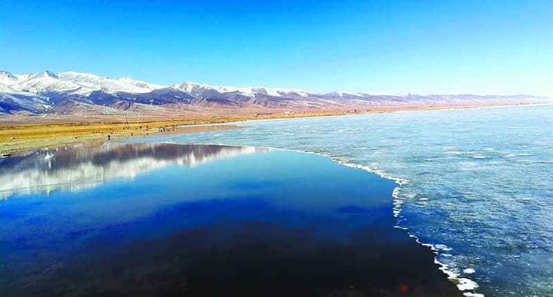 Snow-capped mountains reflected in Qinghai Lake