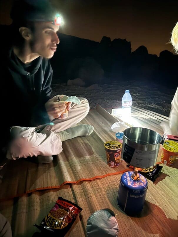 Travelers sharing snacks during a nighttime stargazing stop